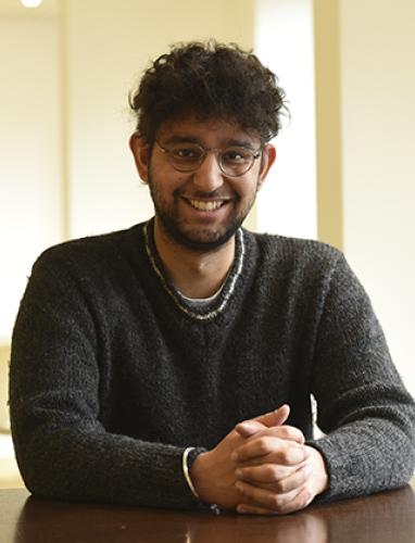 Smiling student sitting at a desk.