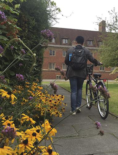 Student pushing bike through the Magdalene Village.