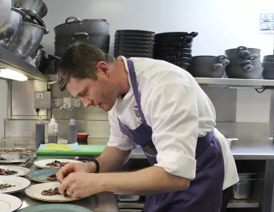 Working at Magdalene, Chef in the kitchen plating up food